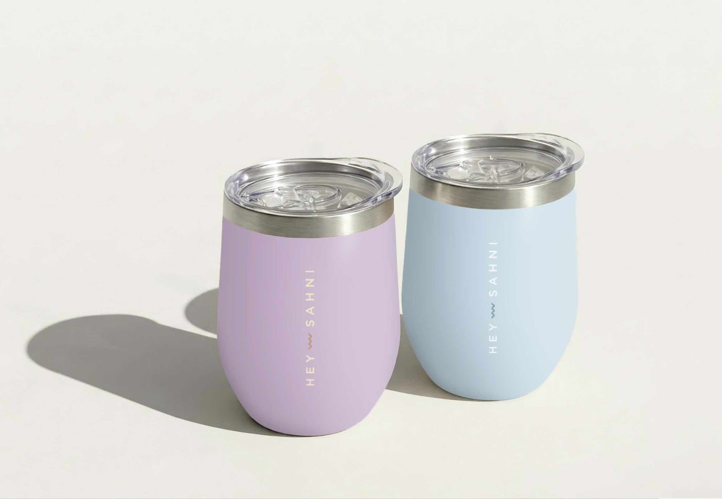 Two pastel-colored reusable cups in lilac and blue