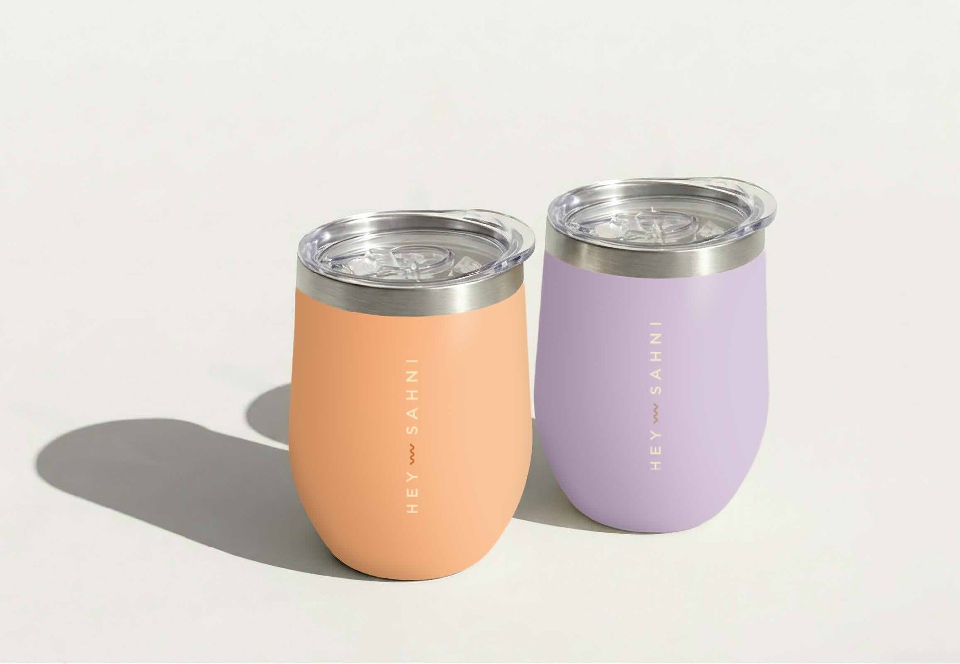 Reusable coffee cups in orange and lilac tones